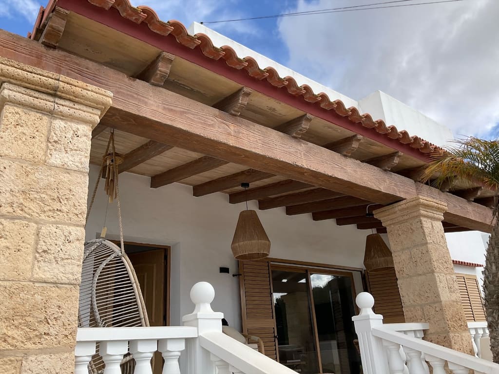 Contraventanas de lamas de madera en el porche de una casa de Ibiza