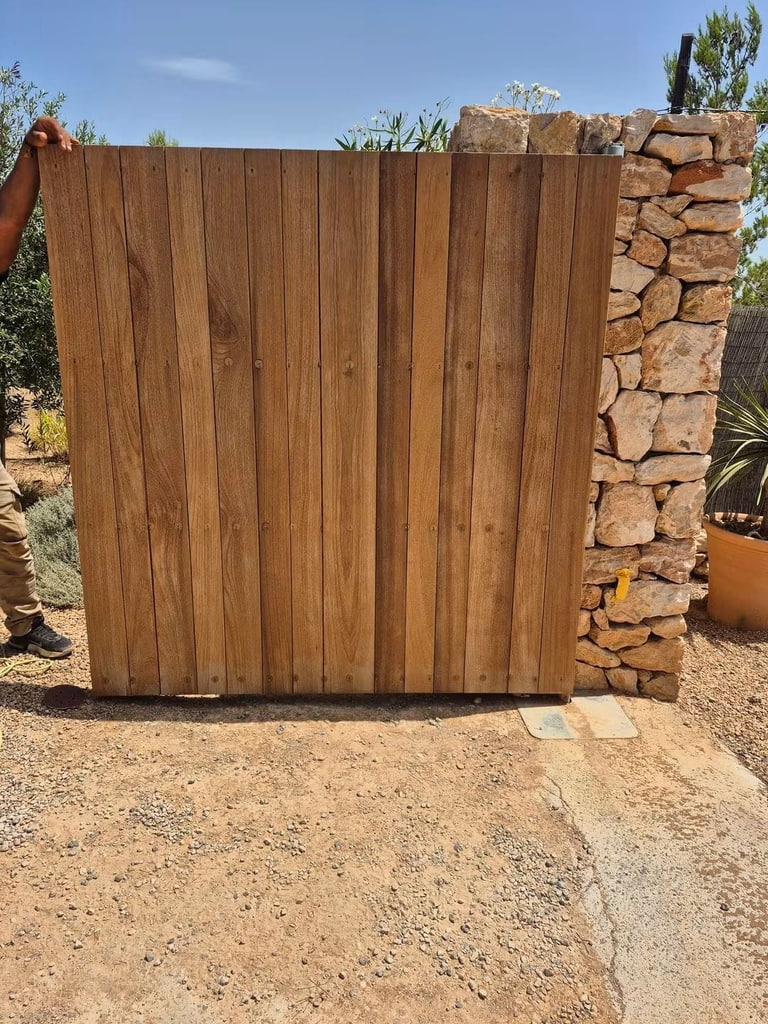 Portón de tablones de madera maciza junto a un muro de piedra, Ibiza