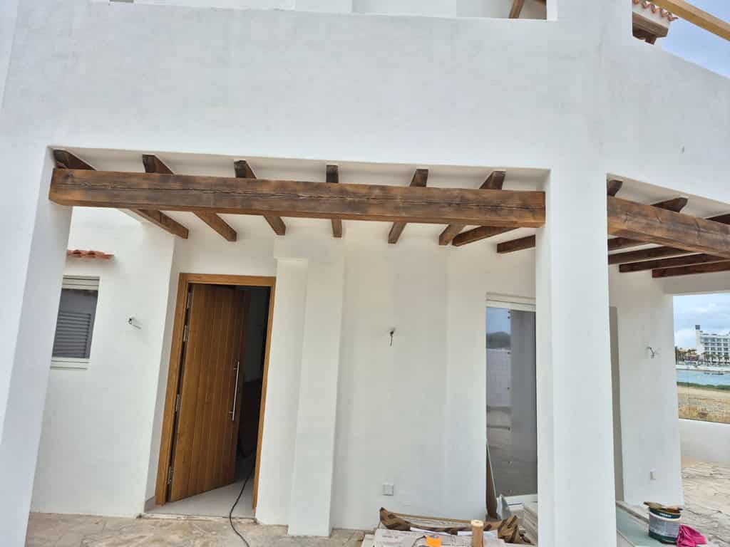 Puerta de entrada de madera maciza de gran formato en una casa de Ibiza