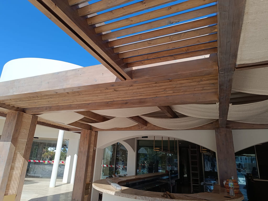 Estructura de madera con lamas y toldos sobre la barra de un beach club, Ibiza