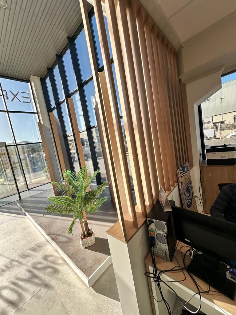 Separador de listones verticales de madera en una oficina con grandes ventanales, Ibiza