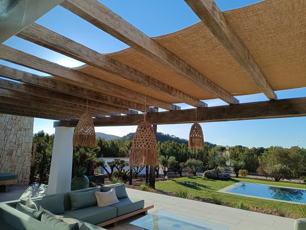 Pérgola de vigas de madera con cañizo sobre zona chill-out con vistas a la piscina, Ibiza